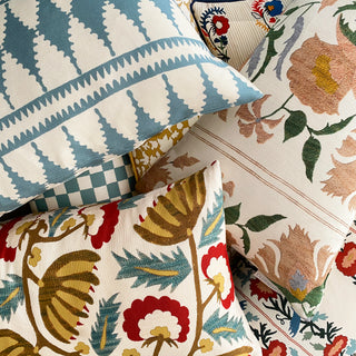 Collection of patterned pillows with geometric and floral designs.