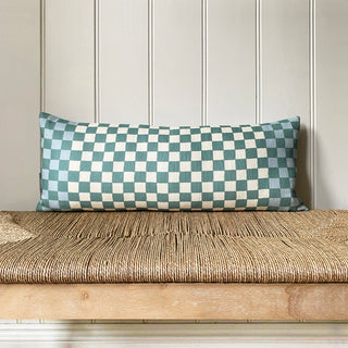 Checkered pillow on a wooden bench against a paneled wall.
