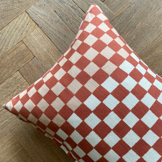 Red and white checkered pillow on a wooden floor
