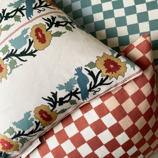 Close-up of decorative pillows with floral and checkered patterns.