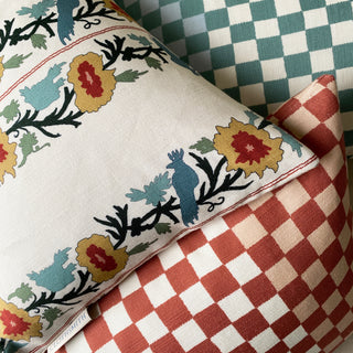 Close-up of decorative pillows with floral and checkered patterns.