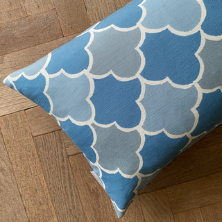 Blue pillow with white cloud pattern on a wooden floor